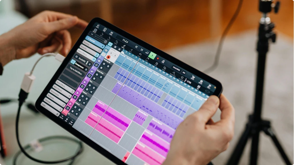 Best Audio Interface for iPad - Top 5 Picks 2025. Person holding an iPad manipulating a DAW